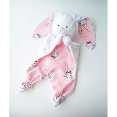 a stuffed animal laying on top of a white table next to a pink and white bunny