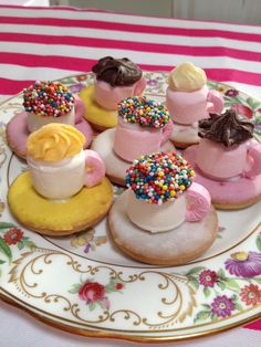 a plate topped with donuts covered in frosting and sprinkles on top of a table