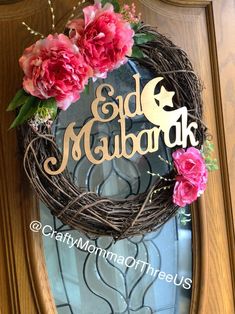 the front door is decorated with pink flowers and a gold monogrammed sign that says ed mabark