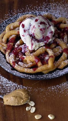 a waffle topped with ice cream and cranberry sauce on a black plate