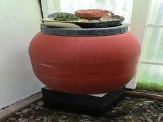 a large red pot sitting next to a window