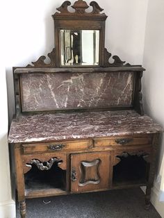 an old wooden bench with marble top and mirror