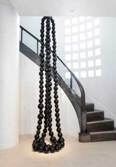 a spiral staircase with black beads hanging from it