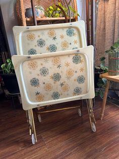 two serving trays sitting on top of each other in front of a wooden table