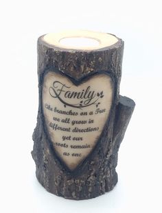 a candle that is sitting on top of a tree stump with a heart carved into it