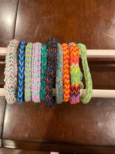 five different colored bracelets sitting on top of a wooden table