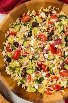 a wooden bowl filled with rice and vegetables