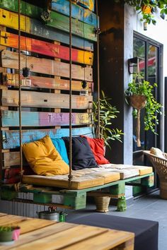 an outdoor seating area with wooden pallets and colorful cushions