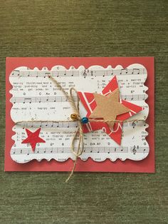 an origami star on top of sheet music with string attached to the bottom