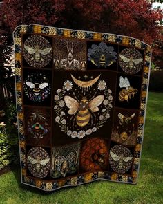 a patchwork quilt with bees and flowers on it in front of some trees,