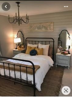 a bed room with a neatly made bed and a chandelier hanging from the ceiling