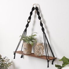 two potted plants sitting on top of a wooden shelf next to a planter