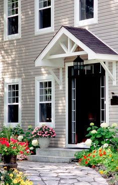 a house with flowers in the front yard and walkway leading to the front door area