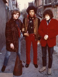 three young men standing next to each other on a city street in the 1970s's