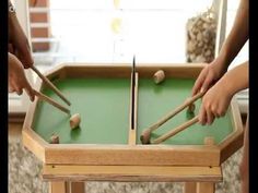 two people are playing pool on a green table