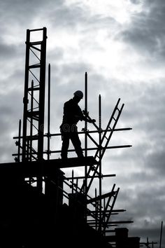 a man standing on top of a building next to scaffolding