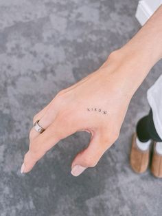 a person's hand with a small tattoo on it