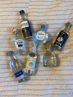 several bottles of alcohol are arranged on a bed