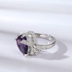 Adorn your finger with this ring and experience the epitome of luxury. The modern design of the bowknot gives a cute twist on a classic chic ring. Crafted in sterling silver, this ring features a purple pear-cut stone and a sparkling bowknot. The dazzling bowknot exudes elegance and cuteness. Impeccably suitable for women in love, you can wear it for your next date.Carat Weight: 4.72 ctStone Size: 8*11 mmStone Type: Jeulia® StoneNumber of Stones: 1 Stone Shape: PearStone Color: Amethyst PurpleCa White Gold Bow Jewelry With Cubic Zirconia, White Gold Cubic Zirconia Jewelry With Bow Detail, White Gold Cubic Zirconia Jewelry With Bow, Luxury Silver Jewelry With Bow Detail, Luxury Silver Jewelry With Bow, Formal Fine Jewelry With Bow Detail, Formal Fine Jewelry With Bow, Luxury Bow Jewelry For Anniversary, Silver Cubic Zirconia Jewelry With Bow Detail