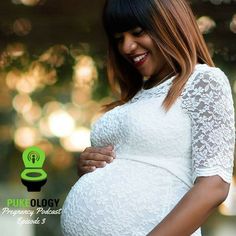 a pregnant woman in white dress smiling at the camera with her hand on her belly