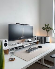 a computer desk with a monitor, keyboard and speakers