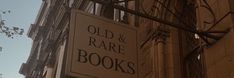 an old and rare book store sign hanging off the side of a building