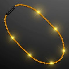 an orange beaded necklace with yellow lights on it and a black lighter in the background