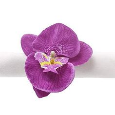 a purple flower sitting on top of a white napkin