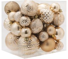 a bunch of gold and white ornaments in a clear box