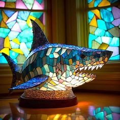 a stained glass shark lamp sitting on top of a table