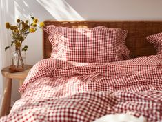 a red and white checkered comforter on a bed