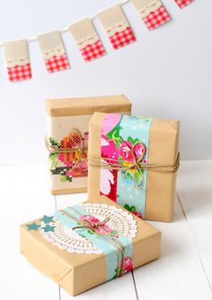 three gift boxes tied with twine and decorated with flowers