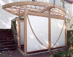 a wooden gazebo in front of a white house