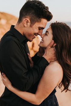 a man and woman embracing each other on the beach