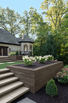 a house with steps leading up to it and flowers growing in the front garden area