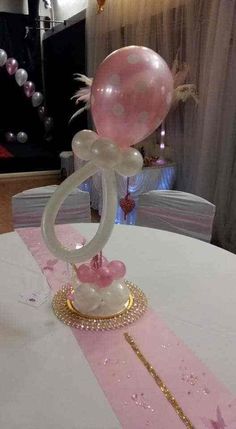 a table with balloons and other decorations on it, including a cake topper in the shape of a balloon