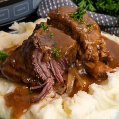 some meat and gravy on top of mashed potatoes