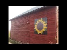 a red barn with a sun painted on the side