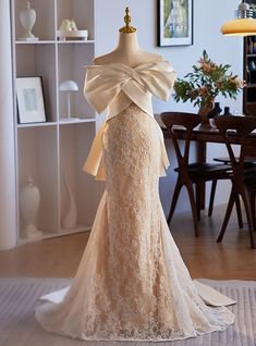 a dress on a mannequin in front of a table with chairs and pictures