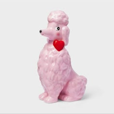 a pink poodle figurine with a heart on its chest