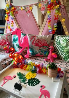 pink flamingos and other decorations on a white table