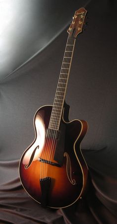 an acoustic guitar sitting on top of a black cloth