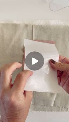 two hands holding a piece of white paper with the word, how to fold a pillow