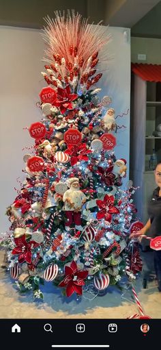 a woman standing next to a decorated christmas tree