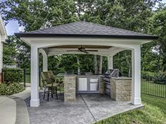 an outdoor kitchen and grill area in a backyard