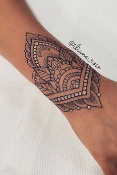 a woman's foot with a tattoo design on the left side of her leg