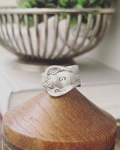 a silver ring sitting on top of a wooden container