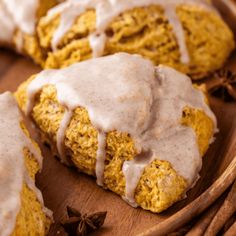 a wooden plate topped with scones covered in icing