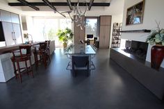 a living room filled with furniture and a fire place next to a dining room table