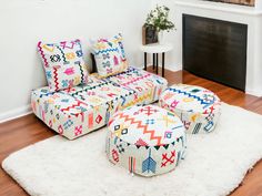 a living room filled with furniture and a fire place next to a white rug on top of a hard wood floor